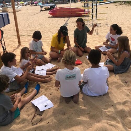 alumnos de campus nautico recibiendo indicaciones sobre temas nauticos en la playa